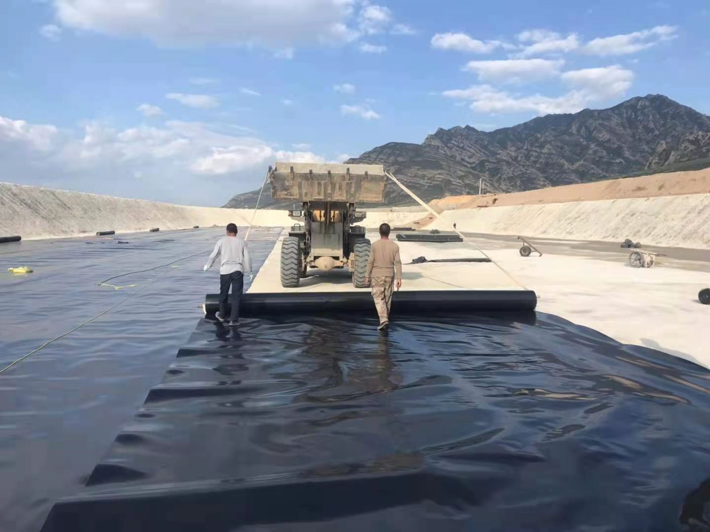 复合土工膜与基座和支撑层应压平贴合，避免架空，排除气泡，确保安全。